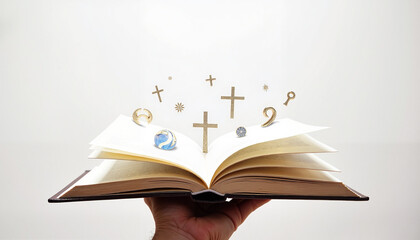 Open book held by hand with symbols of faith and spirituality floating above