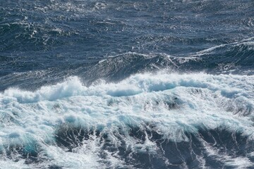 Waves crashing on ocean surface create dynamic and vibrant scene, showcasing beauty of nature power and movement