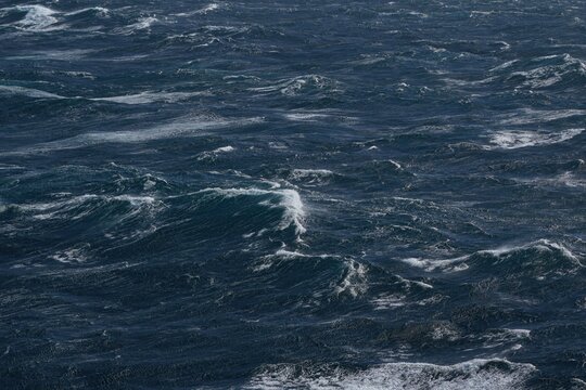 Dark ocean waves with white foam creating dynamic seascape. turbulent water reflects sense of power and movement, showcasing nature raw beauty