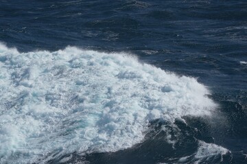 Ocean waves crashing against shore create dynamic and powerful scene, showcasing beauty of nature force and vibrant blue hues of sea