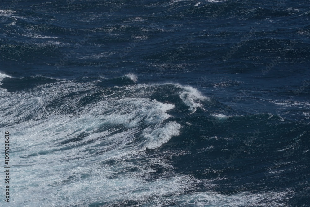 Poster waves crashing on deep blue ocean, creating dynamic and powerful scene. water movement showcases bea