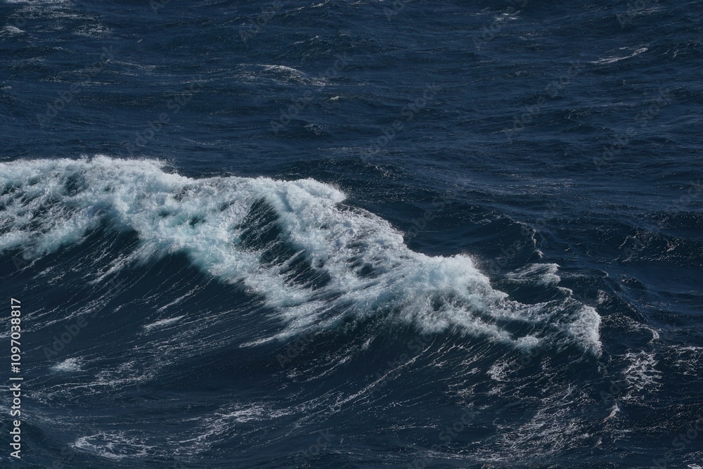 Poster waves crashing on deep blue ocean, creating dynamic and powerful scene. water surface reflects light