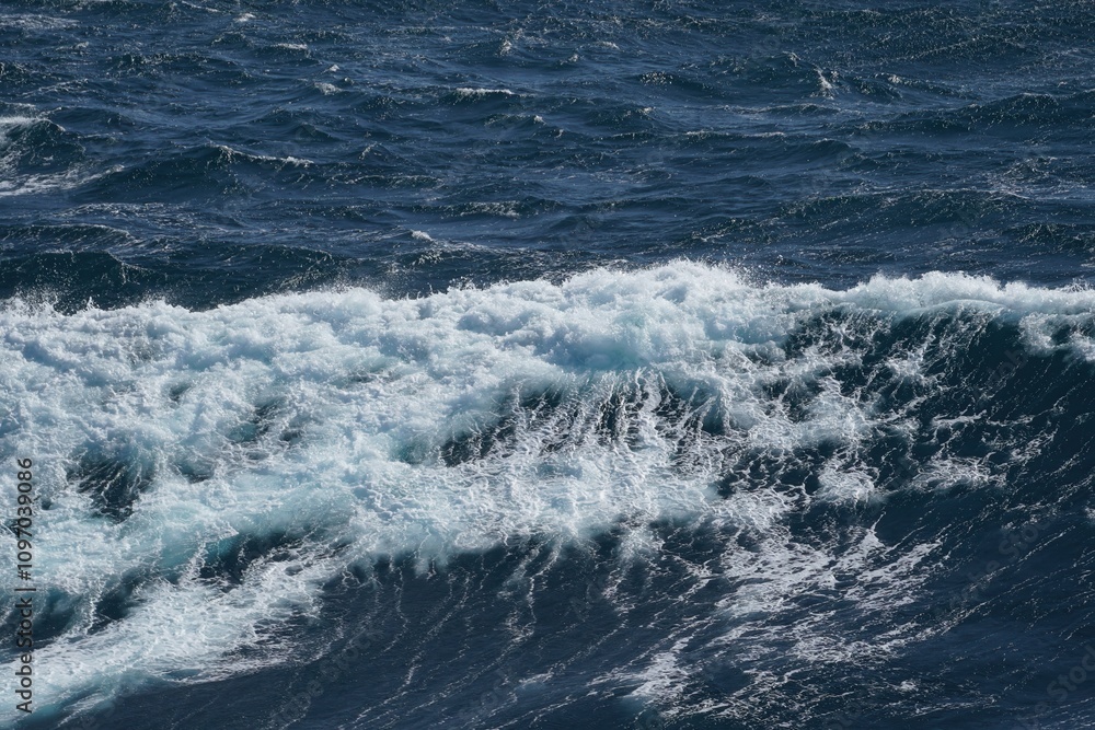 Poster waves crashing on ocean surface, creating dynamic and vibrant scene. deep blue water contrasts with 