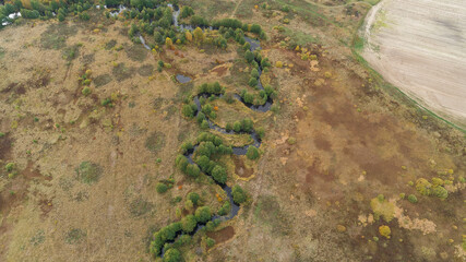 River runs through a field of grass and trees