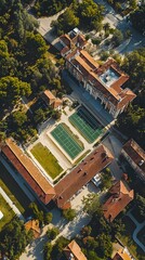 Fototapeta premium Aerial view of a tennis court surrounded by lush greenery and classic architecture.