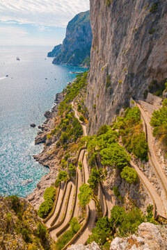 Captured on Capri Island, the photo reveals the historic Phoenician Steps, a steep stone staircase surrounded by natural beauty, leading up the cliffs with panoramic sea views.