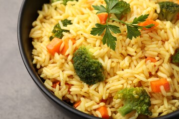 Tasty rice with vegetables on grey table, closeup