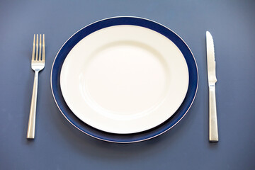 Empty plate top view with metal cutlery next to it
