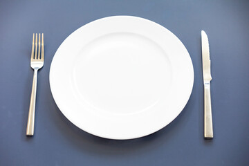 Empty plate top view with metal cutlery next to it