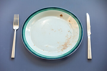 Empty plate top view with metal cutlery next to it