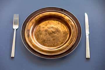 Empty plate top view with metal cutlery next to it