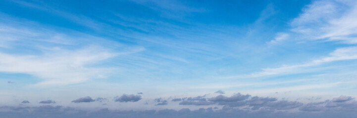 Blue sky covered with white layered clouds in sunny weather