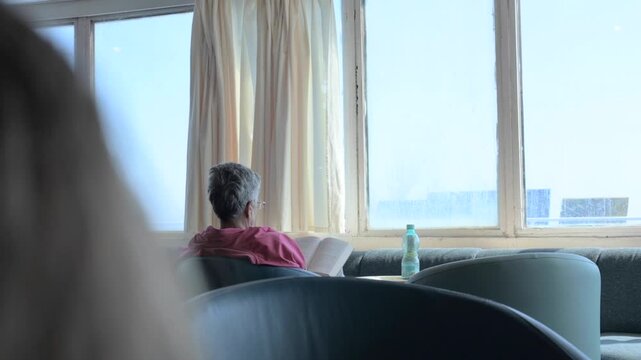tranquil video capturing passengers seated in the lounge of a ferry during their journey, gazing out at the sea through large windows. Perfect for content related to travel, transportation, relaxation