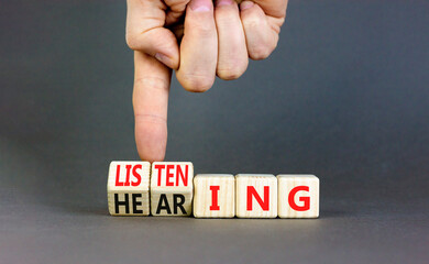 Listening or hearing symbol. Businessman turns wooden cubes and changes a concept word Listening to...