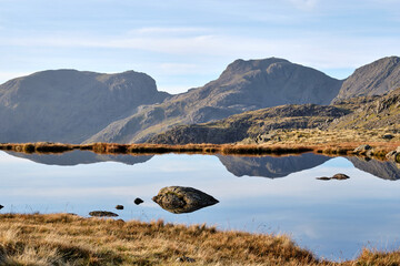 The summit of Scafell Pike reflected in a tarn at Three Tarns, Bowfell, Great Langdale, Lake District, UK