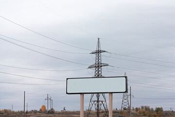 A white sign is on a pole next to a power line