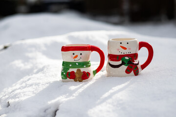 cute snowman shaped tea cups in snow