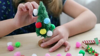 Christmas handcraft, child makes a garland to fir tree, art decor. Holiday prepearing.New year concept.
