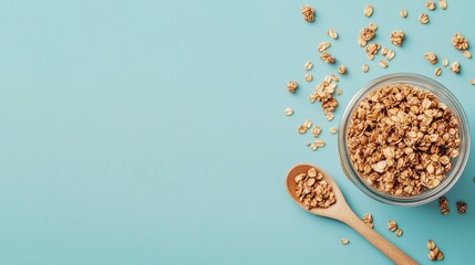 Crunchy granola in a glass jar with a wooden spoon on a light blue background