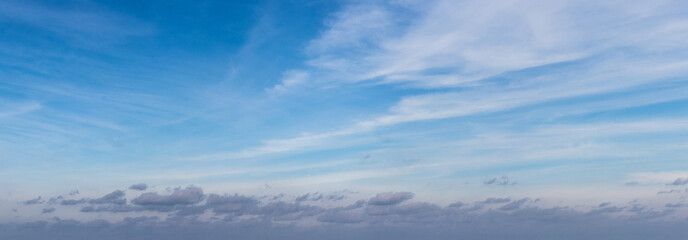 Blue sky covered with white layered clouds in sunny weather