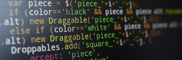 Image showing close-up view of JavaScript code written on dark computer screen. Various colorful syntax elements such as variables and operators are visible