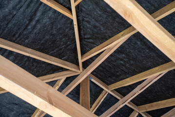 Wooden framework supports a roof at a construction site