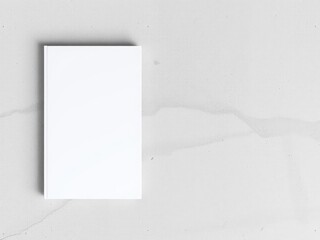 A top view shot of a hardcover book mockup displayed on a concrete wall, presentation, blank cover