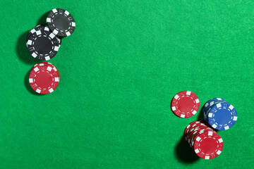 Poker chips on green table, flat lay. Space for text