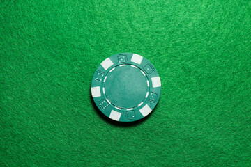 Poker chip on green table, top view