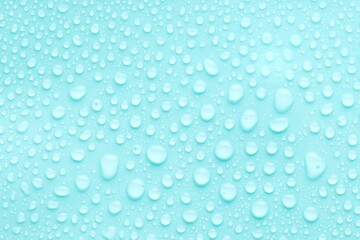 Water drops on turquoise background, top view