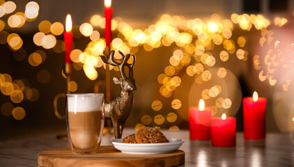Aromatic coffee in glass, tasty cookies and burning candles on table against blurred Christmas lights. Bokeh effect