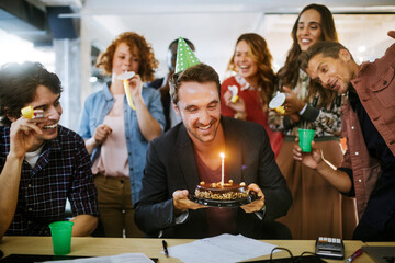 Group of young people celebrating a birthday in the office