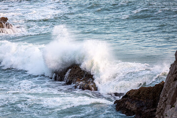 Rocks in the Man O War bay being hit by large waves at sunset