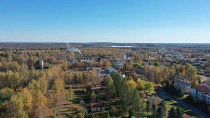 Taiga in autumn in Russia. Northern part of Russia. Siberia from a height. Human settlements in the North of Russia from a height. Blue sky not northern forest, blue lakes, red spruces.