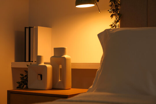 Stylish living room interior with bed, bedside table and lamp