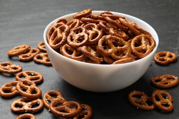 Delicious pretzel crackers on black table, closeup