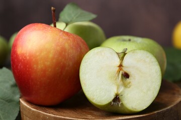 Different ripe apples on wooden board, closeup