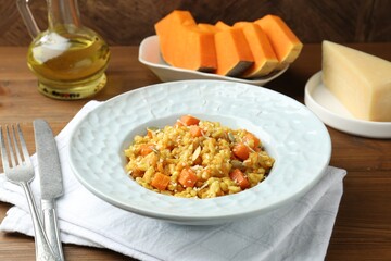 Delicious pumpkin risotto served on wooden table, closeup