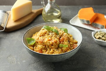Delicious pumpkin risotto on grey table, closeup