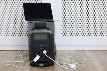 Modern portable power station, charging attached devices indoors, space for text