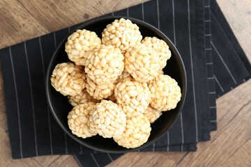 Tasty puffed rice balls on wooden table, top view