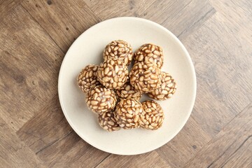Tasty chocolate puffed rice balls on wooden table, top view
