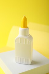 One bottle of glue on yellow background