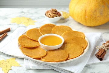 Tasty pumpkin pancakes on white marble table, closeup