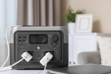 Naklejka premium Devices charging from portable power station on white table indoors