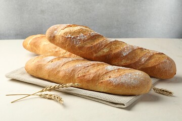 Fresh baguettes and spikes on beige table