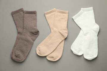 Different soft socks on light grey background, flat lay