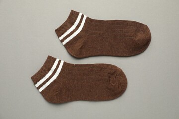 Pair of soft socks on light grey background, top view