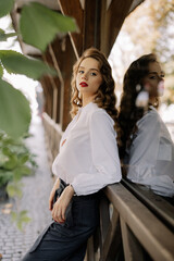 Elegant businesswoman leaning on wooden railing in a corridor