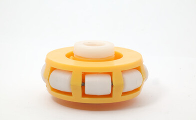 A yellow plastic omni wheel on a white background. An omni wheel used for robot wheels, toys, or DIY products. Used by robotics or electronics enthusiasts.